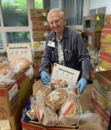 A smiling Tom shows off the bread at his station at the Edmonds Food Bank.